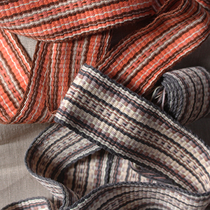 photo de deux galons larges tissés sur un inkle loom
				dans les tons beige, brun et orange